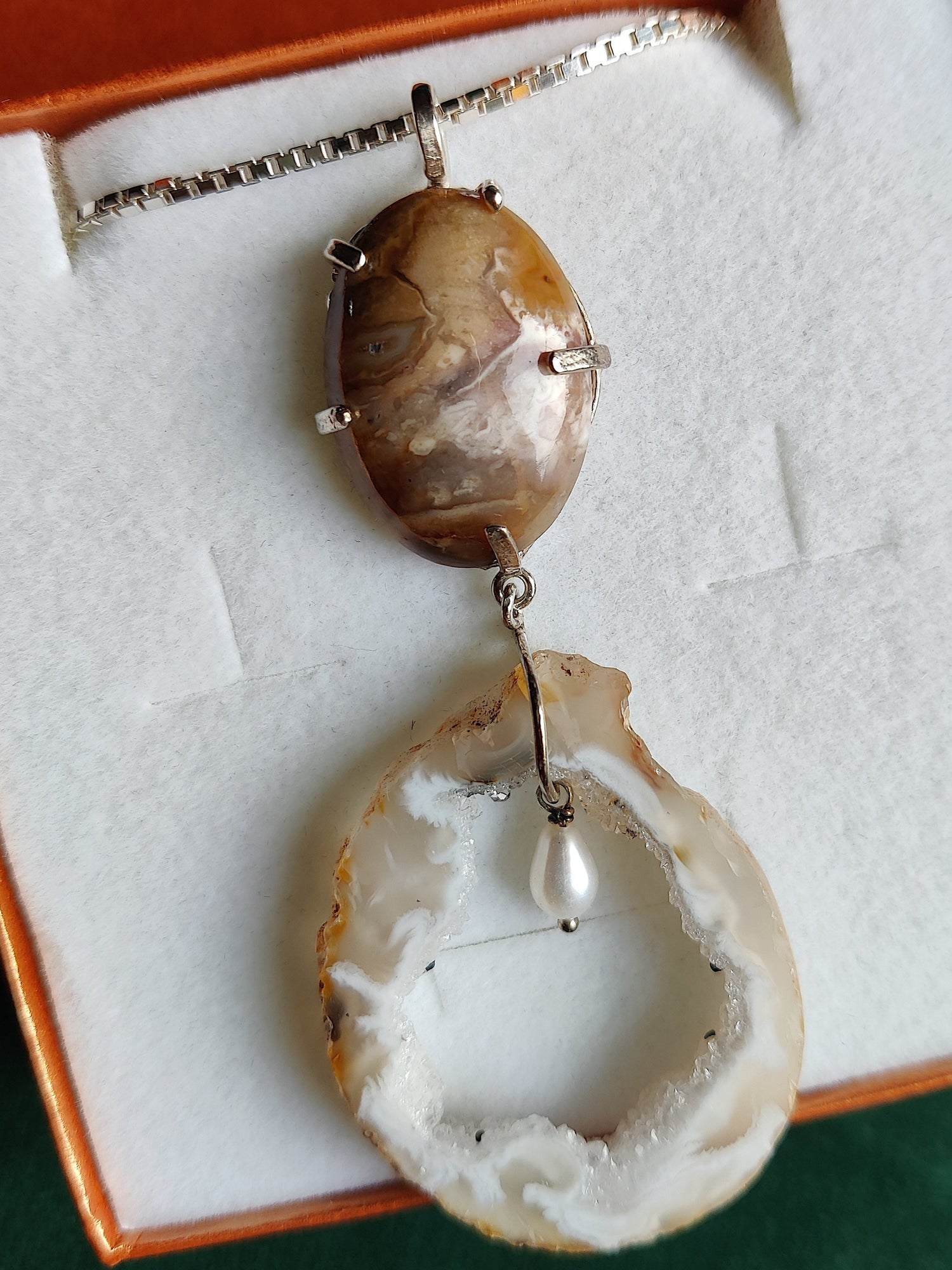 zilvere hanger met een hangende parel daarrond een agaat vast aan een jaspis steen