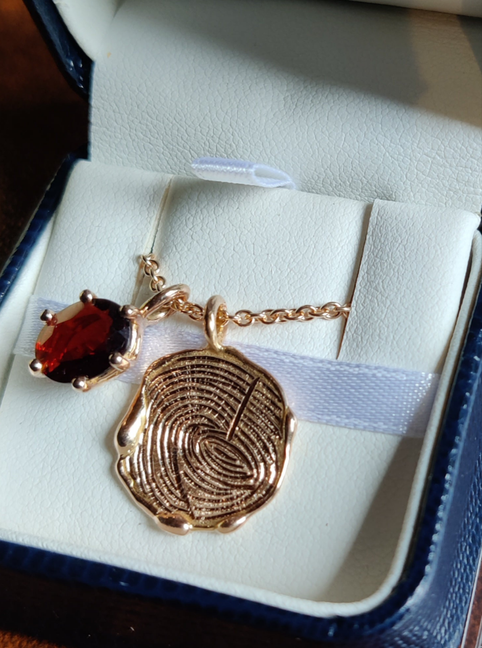 Rouw juweel in 18k rood goud en granaat met vingerafdrukken.
