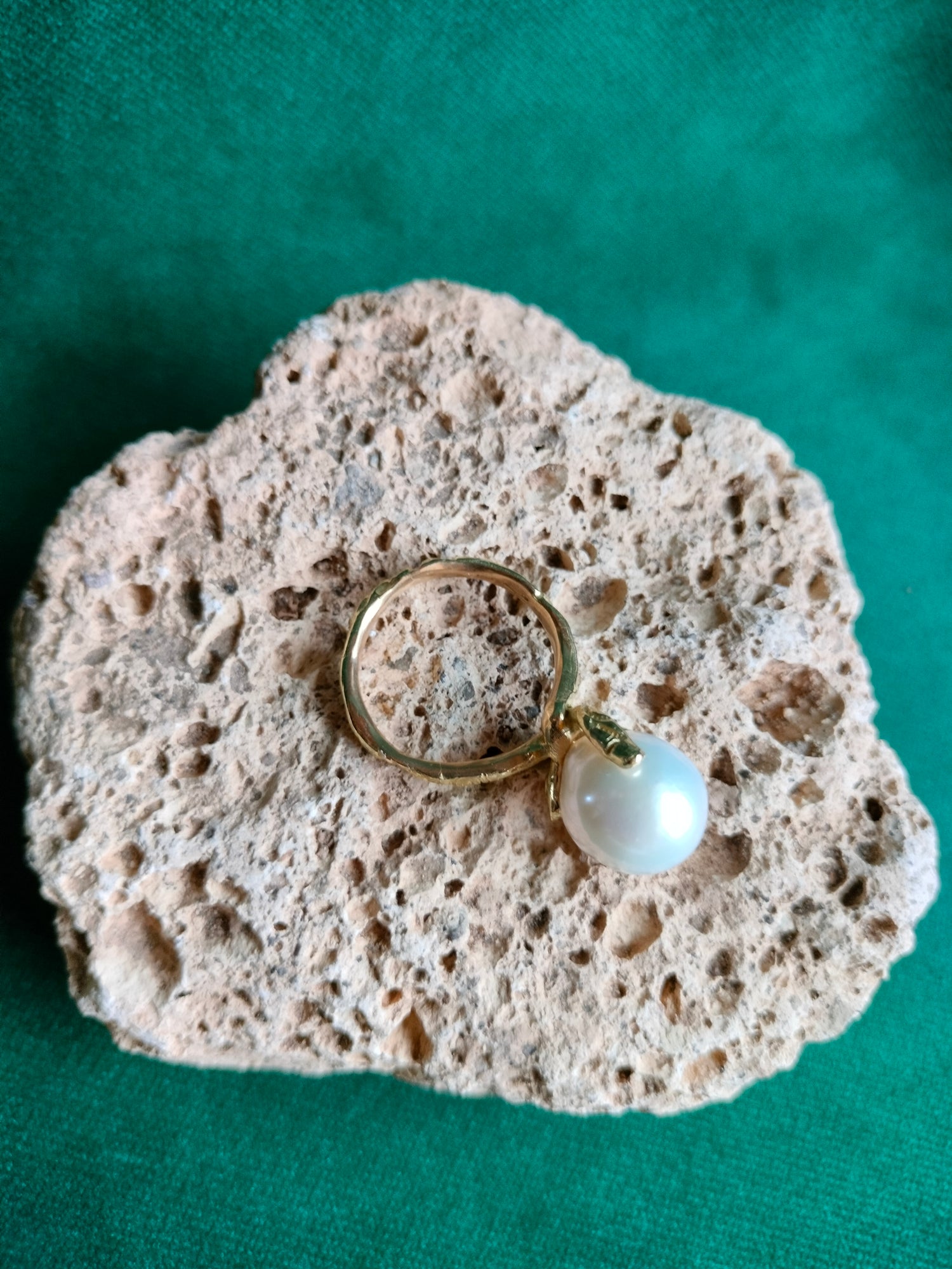 Witte barokke parel in geel gouden ring.