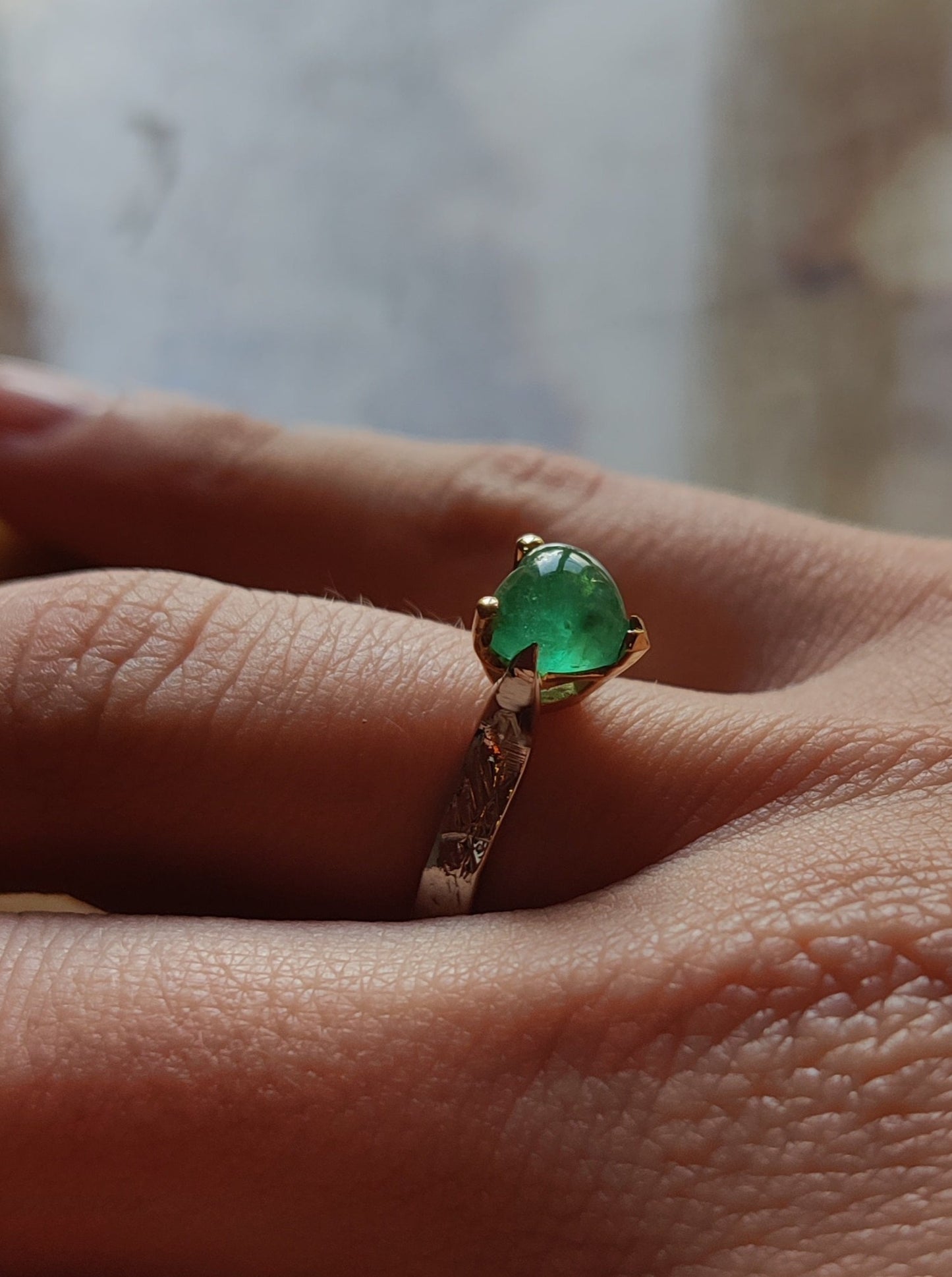 ring in het geel en wit goud. Aan de bovenkant zit er een groen edelsteen hart met pootjes en aan de onderkant van de ring is er een geelgouden oriëntaals geïnspireerd hart. Het groene hart van smaragd is bol.