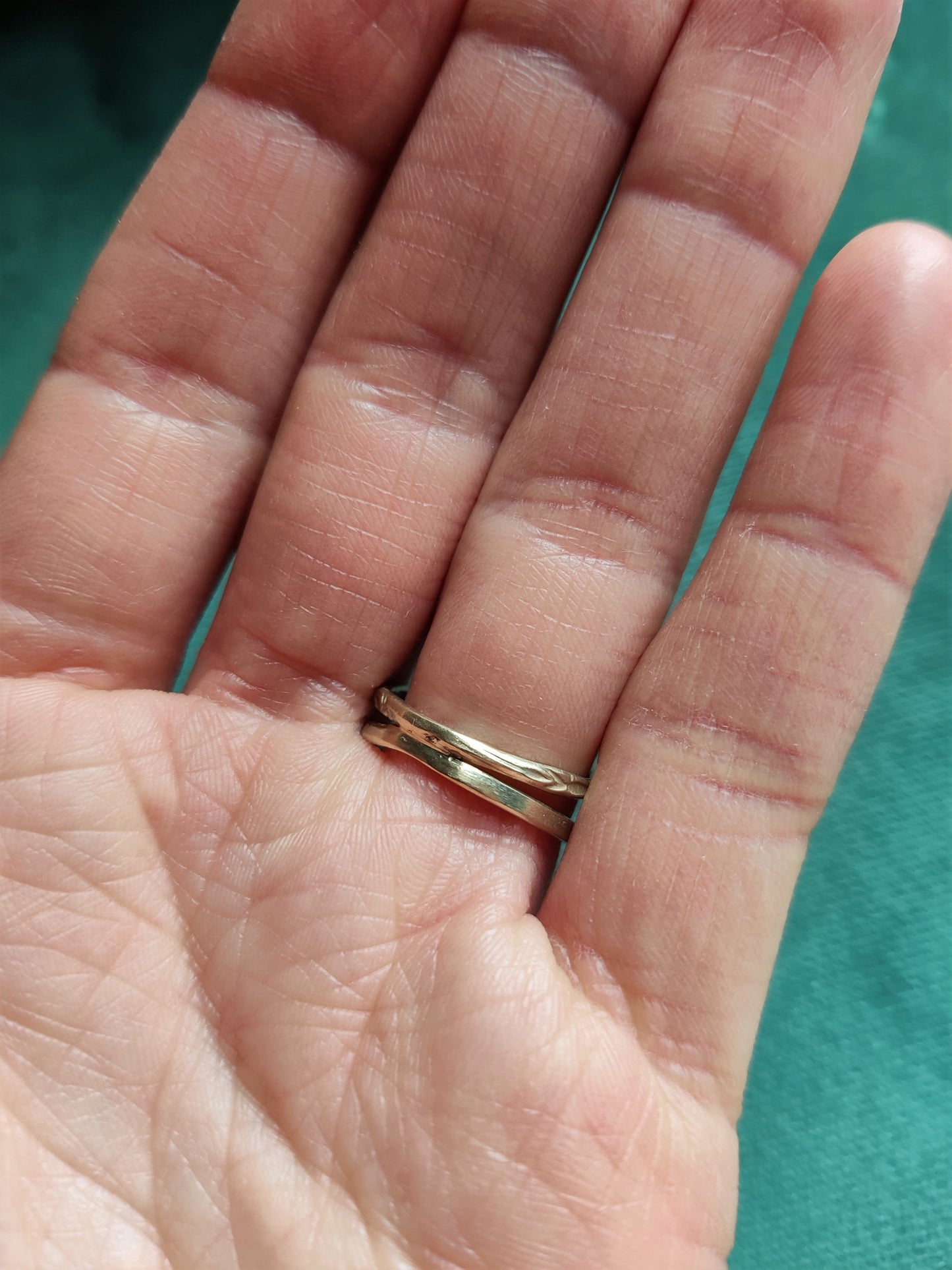 Een unieke originele ring met open bandje. De bandjes hebben een uniek patroon dat lijkt op bloemetjes. In het midden zit een bloemvorm met steentjes. Groene ronde saffier en antiek roos geslepen diamanten.