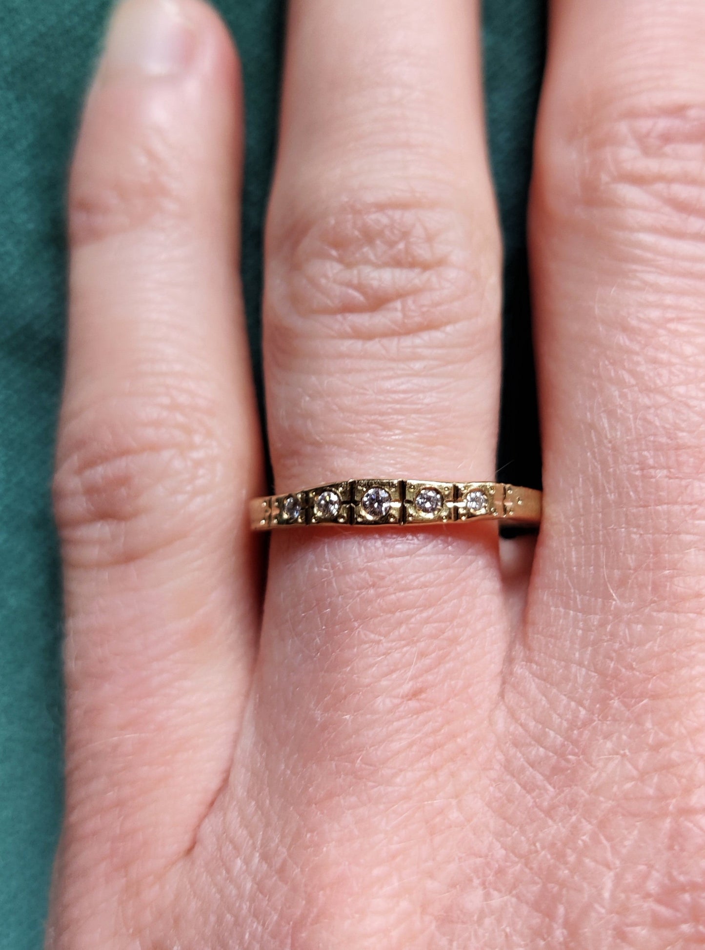 Smalle ring in 18k geel goud met witte diamanten. De ring lijkt wel uit de art deco tijd te komen. Het is een geel gouden ring met allemaal lijntjes met de hand in gegraveerd. Deze ring kan perfect als trouwring of als ring om bij andere ringen gedragen te worden.