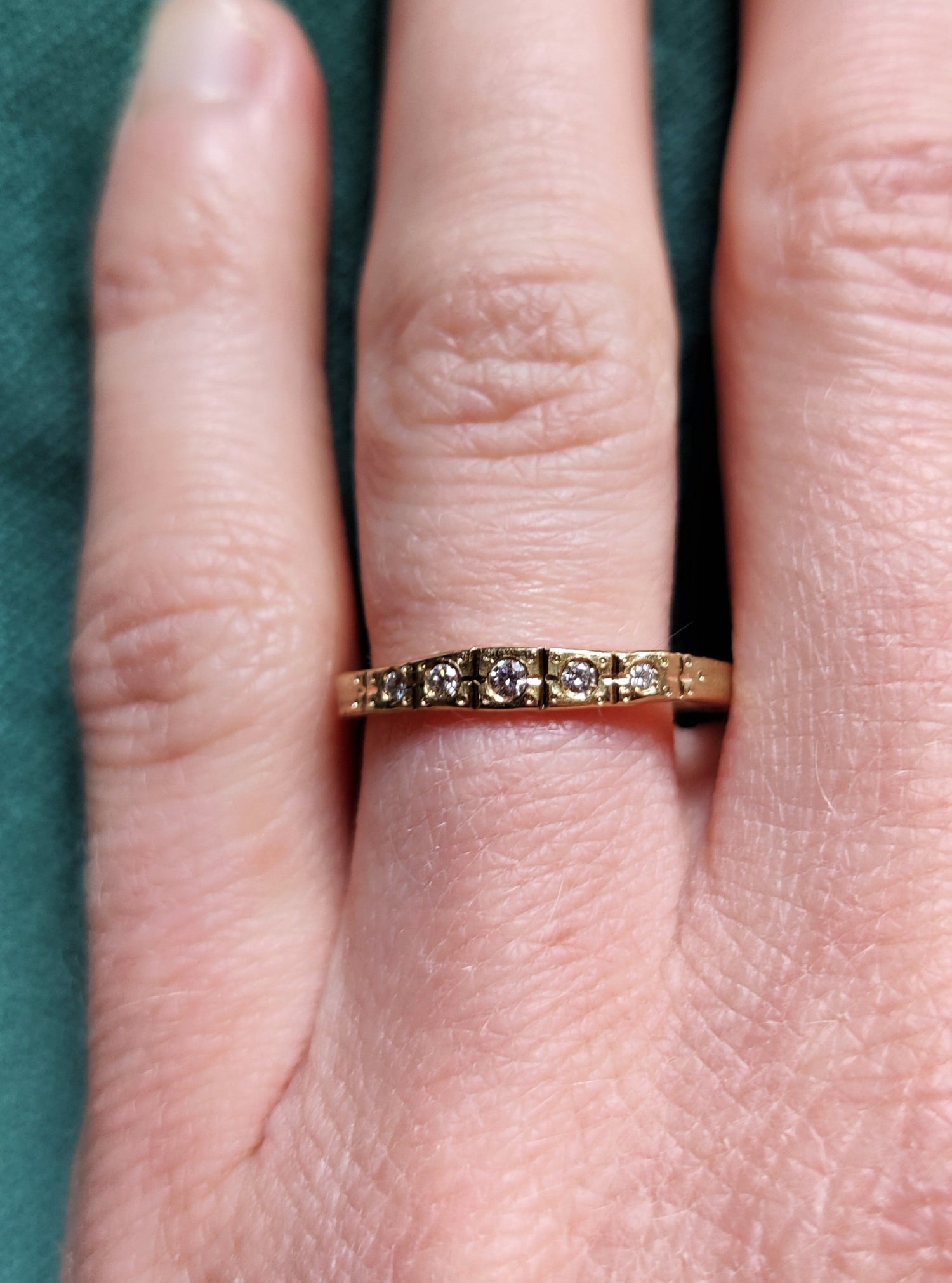 Smalle ring in 18k geel goud met witte diamanten. De ring lijkt wel uit de art deco tijd te komen. Het is een geel gouden ring met allemaal lijntjes met de hand in gegraveerd. Deze ring kan perfect als trouwring of als ring om bij andere ringen gedragen te worden.