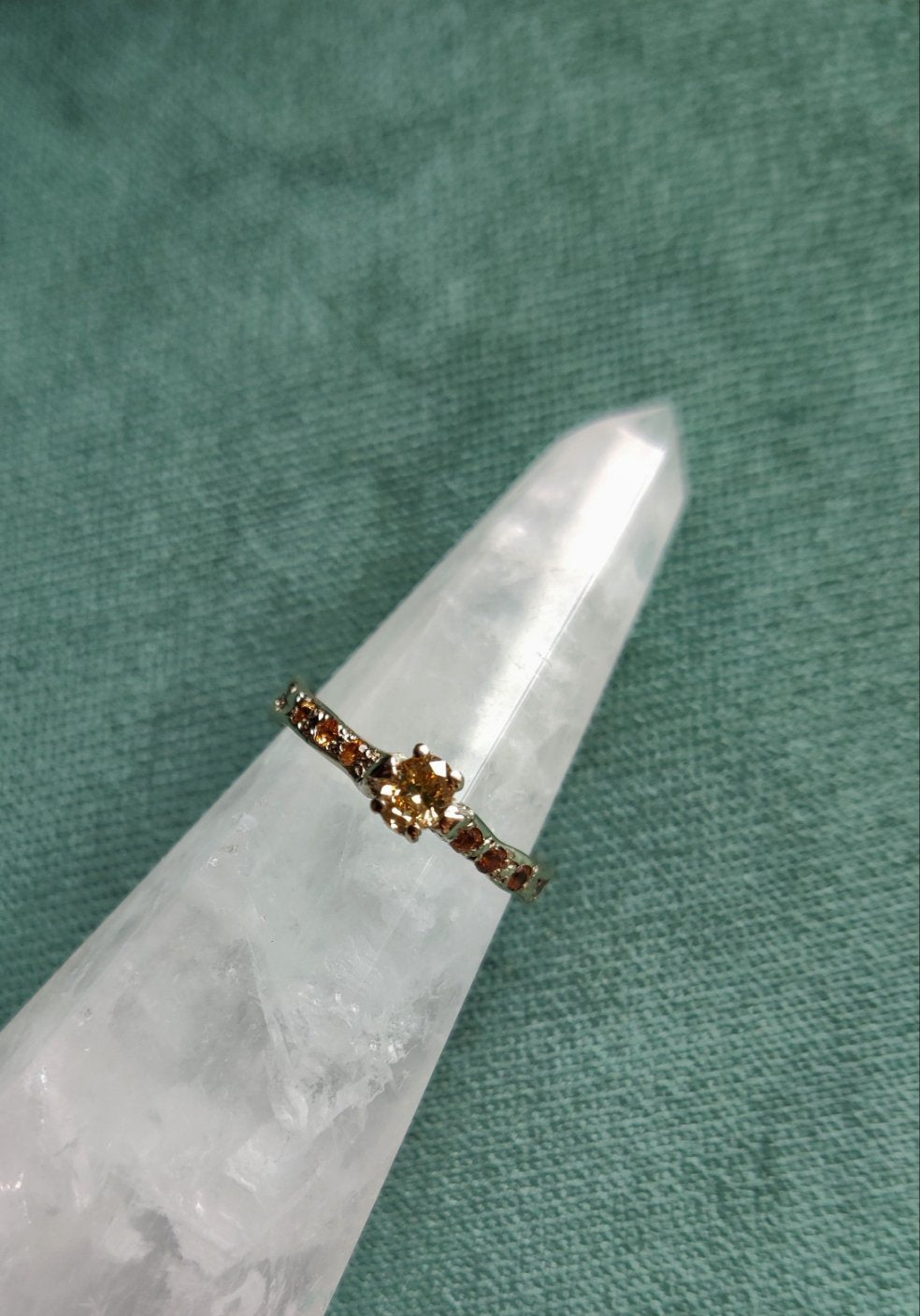 Een verlovingsring waar er maar één van is. Het bandje is wat ruwer, bruter gemaakt. De ring heeft een organisch gevoel en is de combinatie van natuurlijk witgoud en een natuurlijke gekleurde ovalen diamant. Aan de zijkanten zitten oranje saffieren.