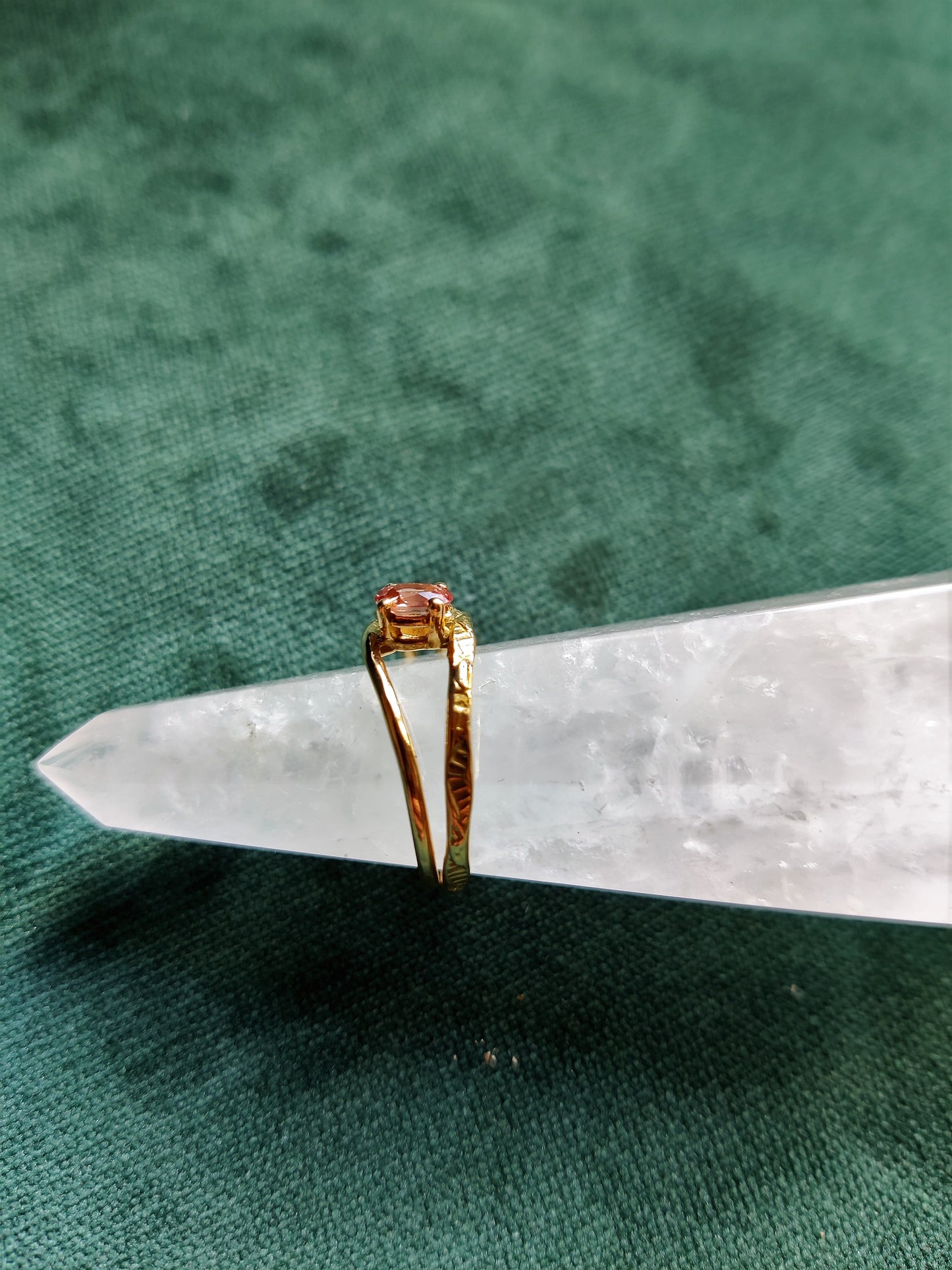 Ring met prachtige roze saffier. De ovale steen heeft de kleur van een perzik en zit met pootjes vast. Het is een fijne ring met dunne bandjes. De bandjes zijn opengewerkt en hebben een blaadjes patroon. De ring is open in het midden en daartussen zit de steen. Saffier is de geboortesteen van september en is erg hard.