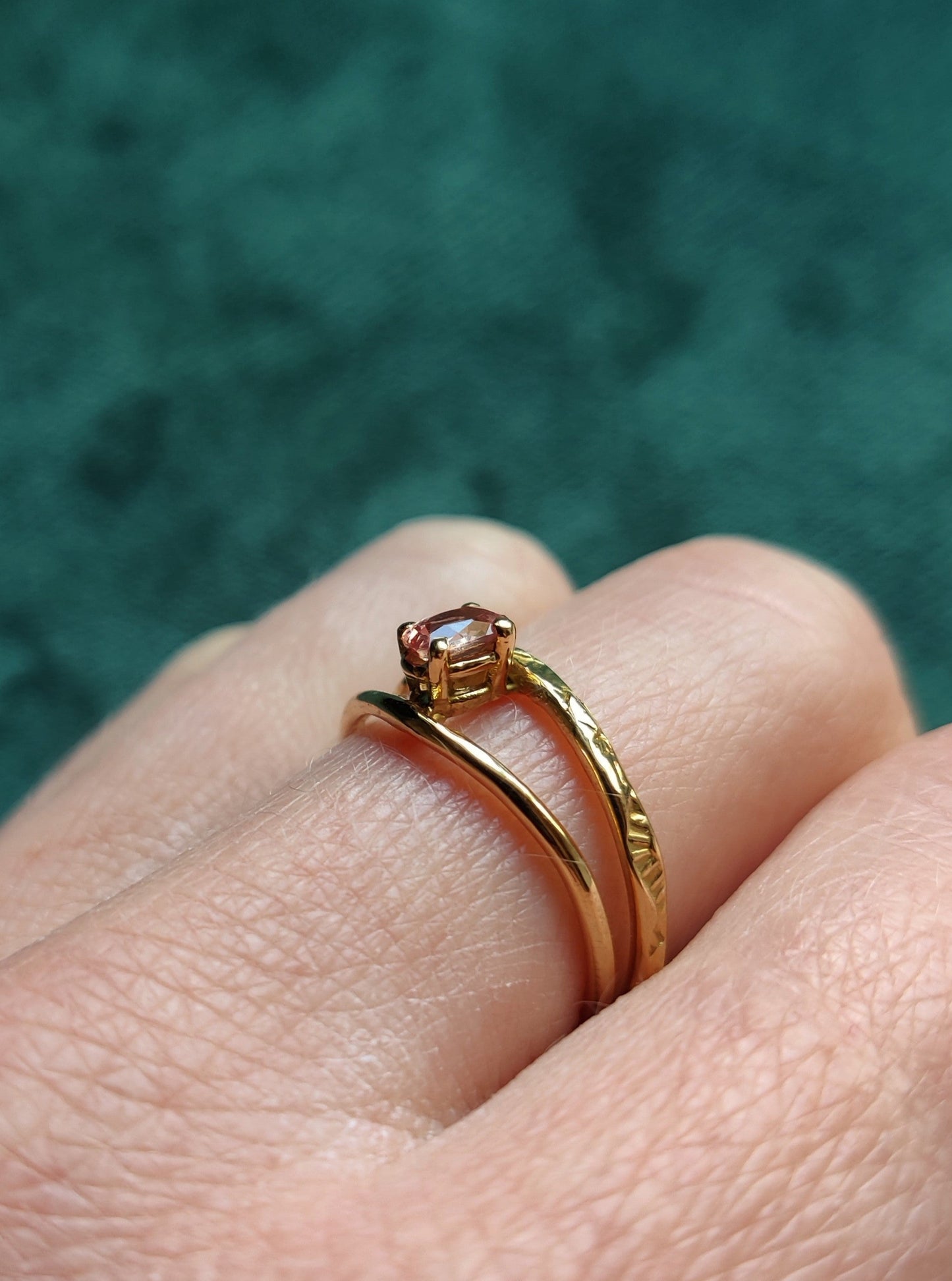 Ring met prachtige roze saffier. De ovale steen heeft de kleur van een perzik en zit met pootjes vast. Het is een fijne ring met dunne bandjes. De bandjes zijn opengewerkt en hebben een blaadjes patroon. De ring is open in het midden en daartussen zit de steen. Saffier is de geboortesteen van september en is erg hard.
