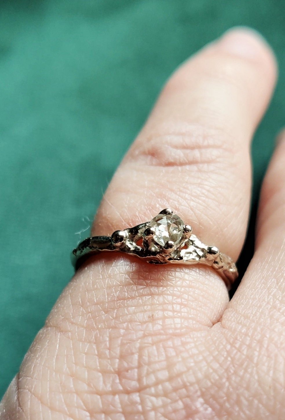 Een verlovingsring met een vintage look and feel in het wit goud. Een solitair met een roosgeslepen diamant dat in een opengewerkt bandje staat.