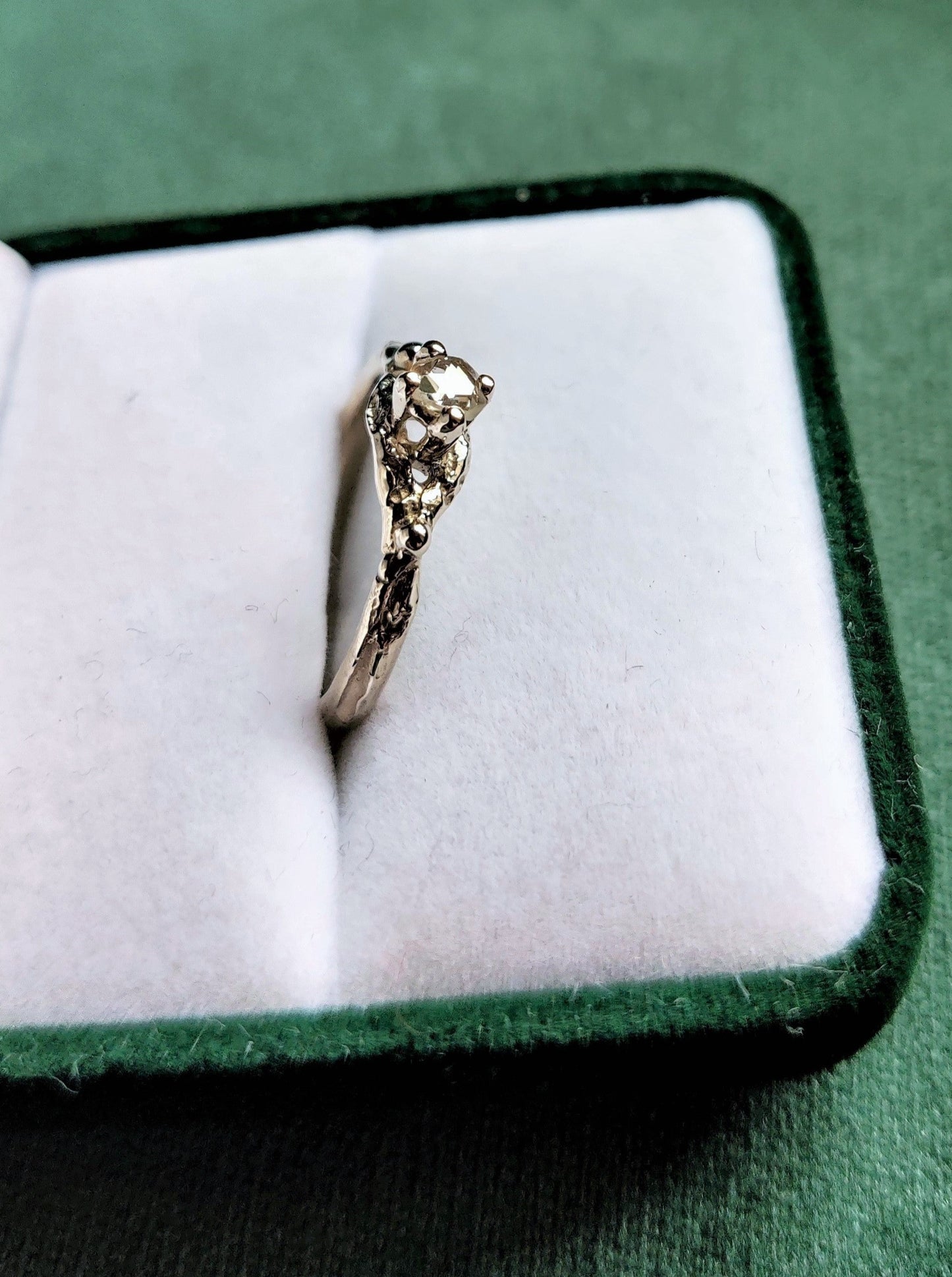 Een verlovingsring met een vintage look and feel in het wit goud. Een solitair met een roosgeslepen diamant dat in een opengewerkt bandje staat.