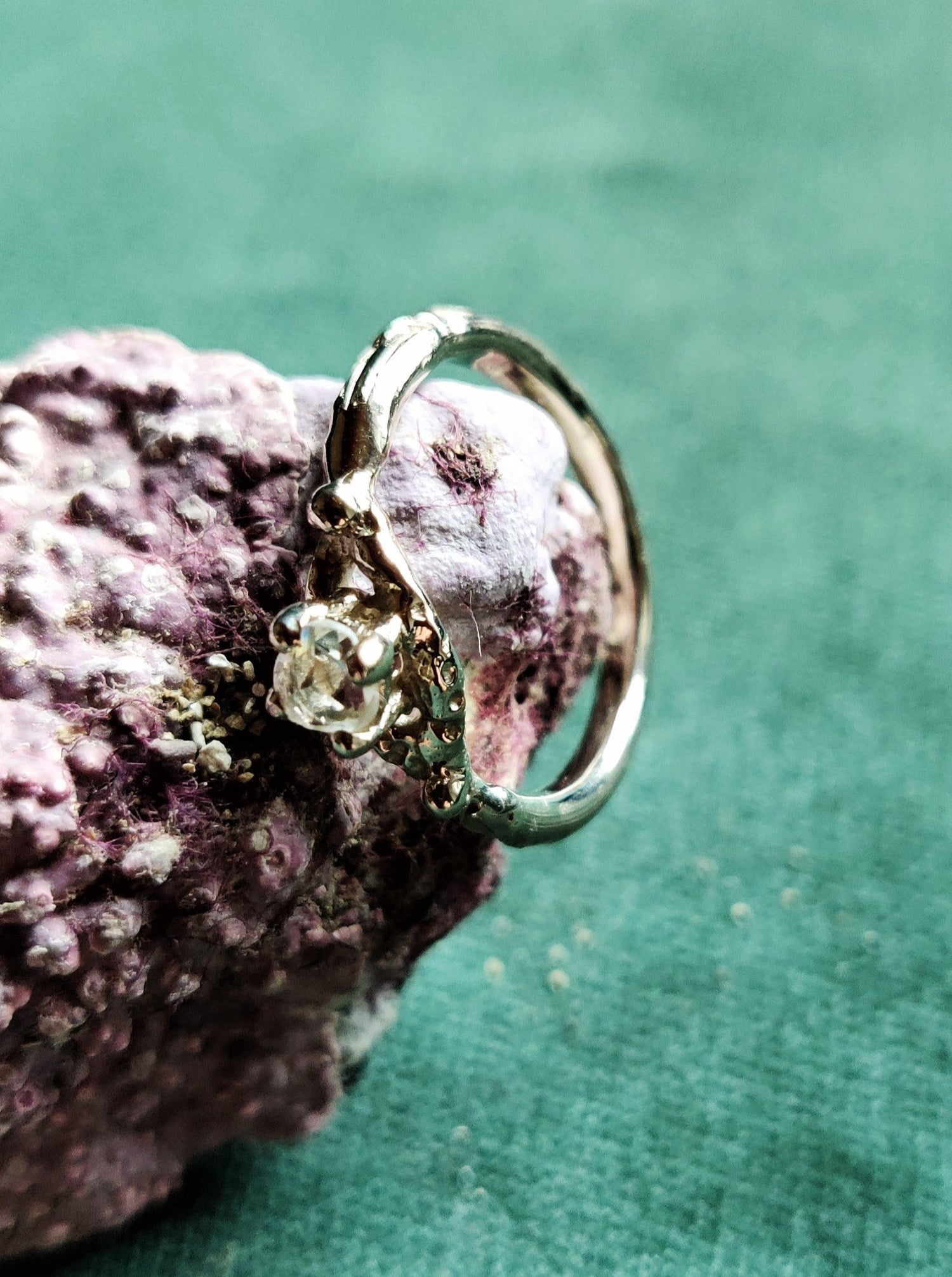 Een verlovingsring met een vintage look and feel in het wit goud. Een solitair met een roosgeslepen diamant dat in een opengewerkt bandje staat.