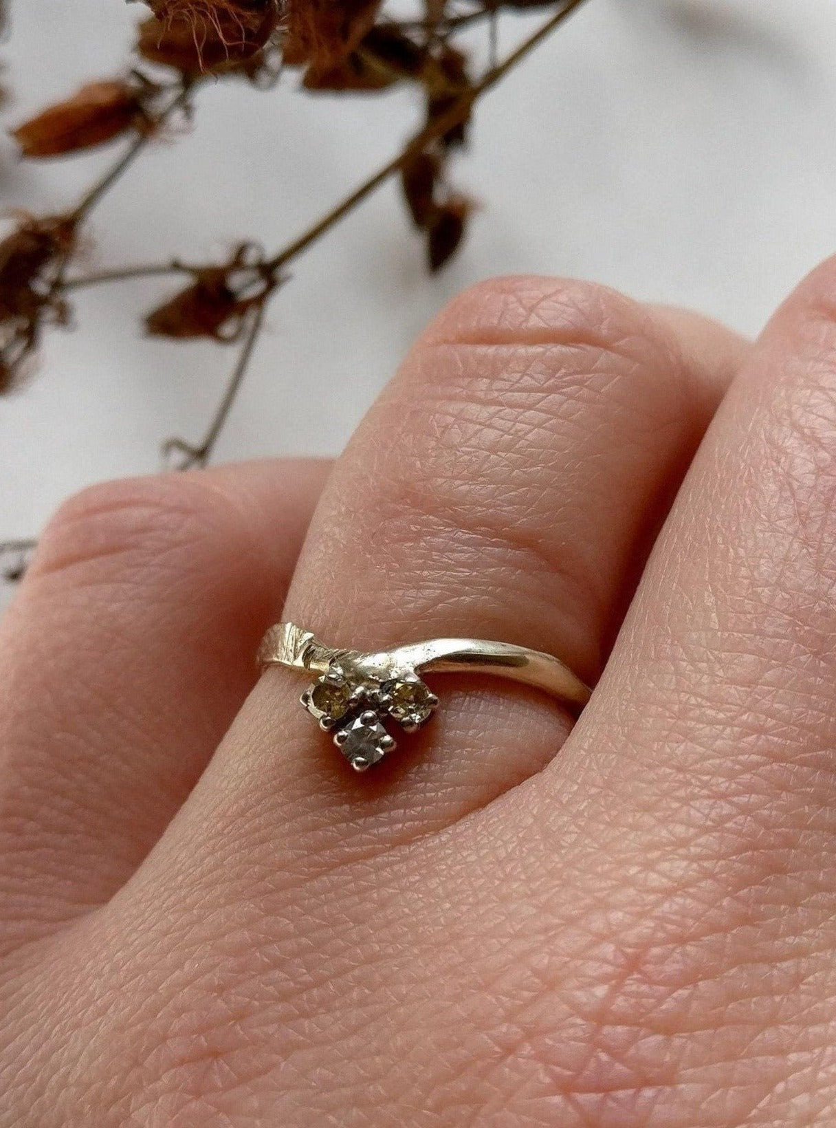 ring in 18k champagne wit goud in een v vorm met drie diamantjes in verschillende natuurlijke tinten.